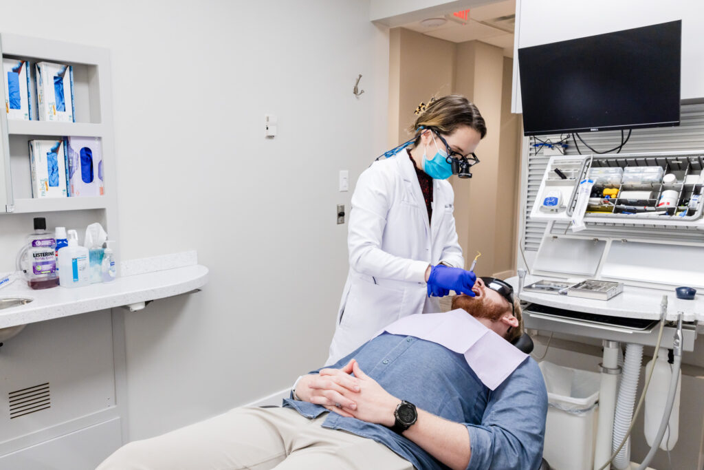 Dentist with a patient during his exam and dental cleaning in Gainesville, VA.