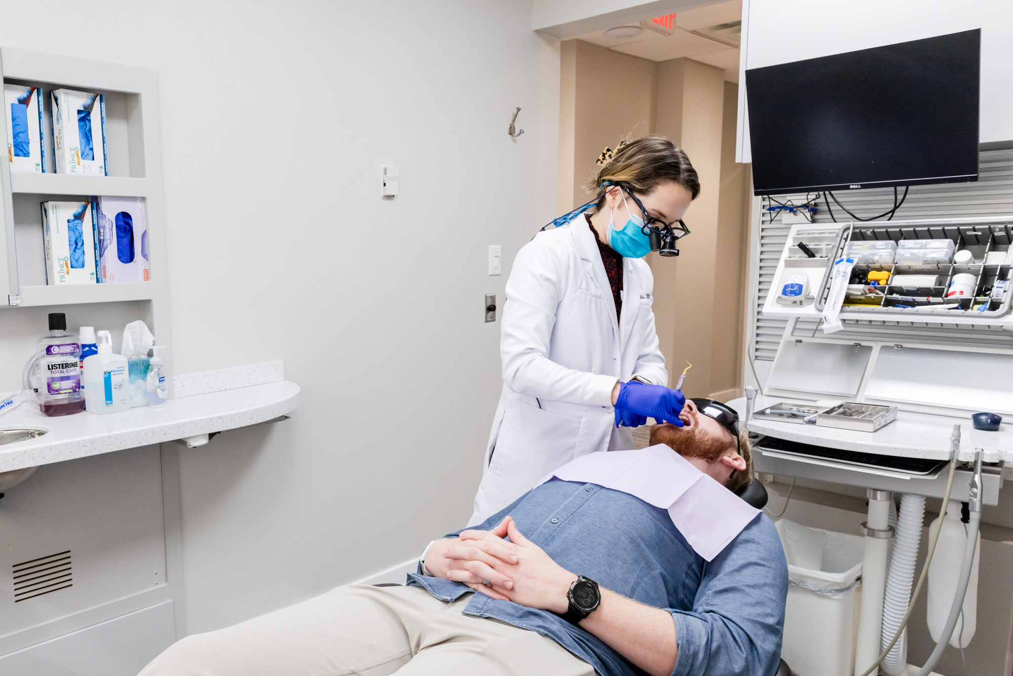 Dentist with a patient during his exam and dental cleaning in Gainesville, VA.