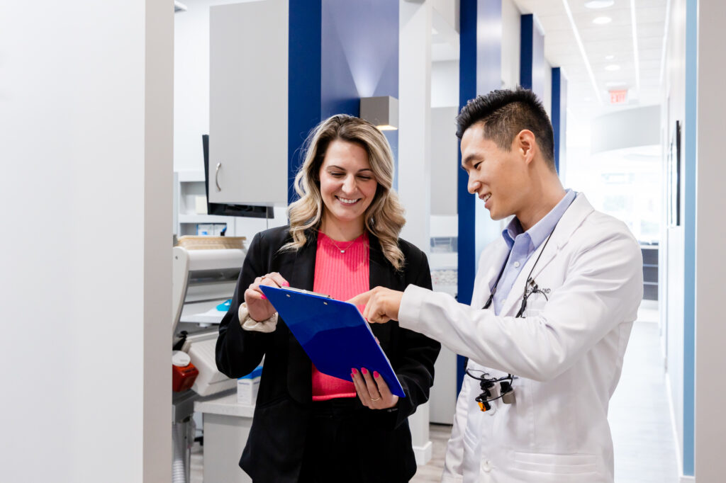 Cosmetic dentist in Herndon talking to a new patient at his dental office before her treatment.