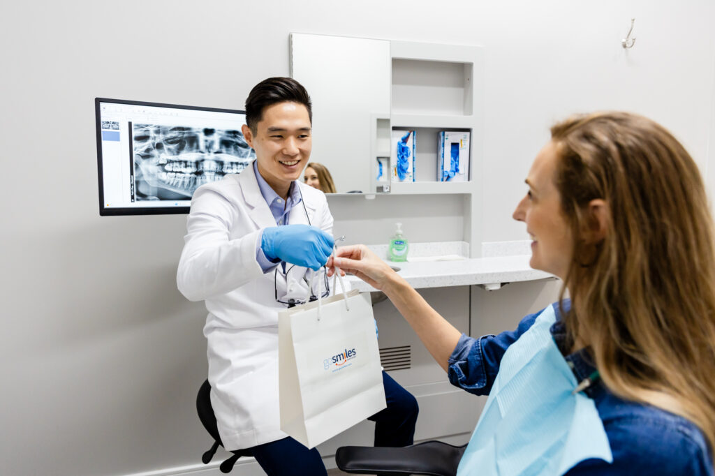 Family dentist in Herndon handing over a teeth whitening kit to a patient.