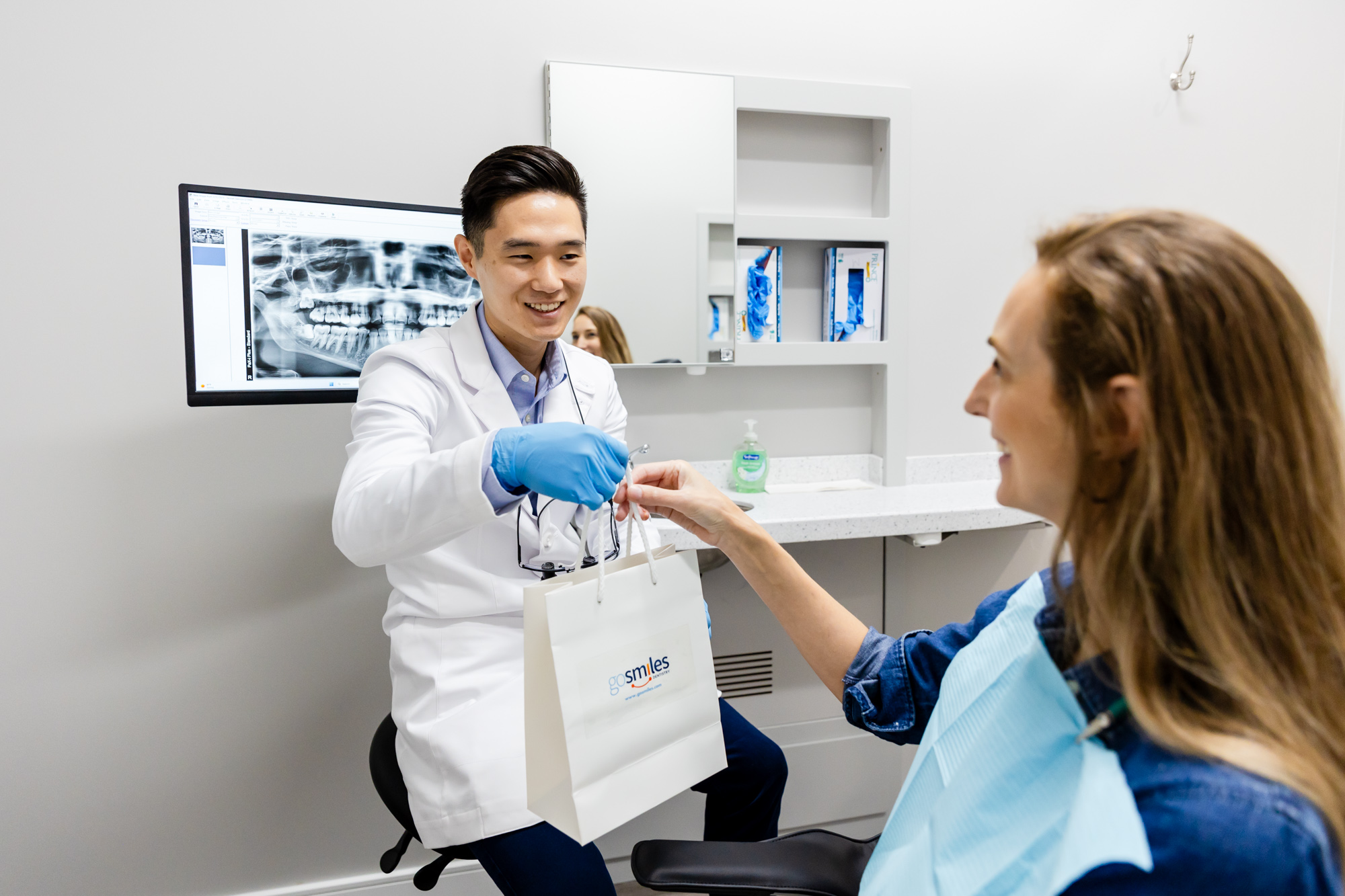 Family dentist in Herndon handing over a teeth whitening kit to a patient.
