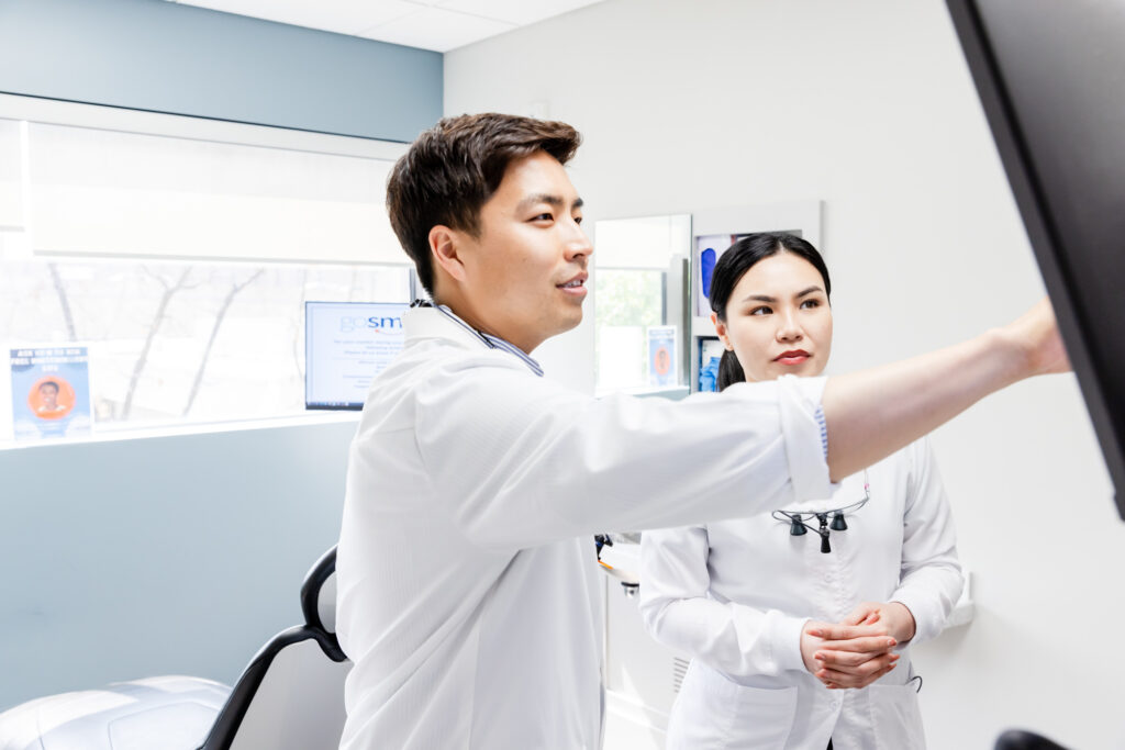 Cosmetic dentist in Herndon talking to his dental assistant.